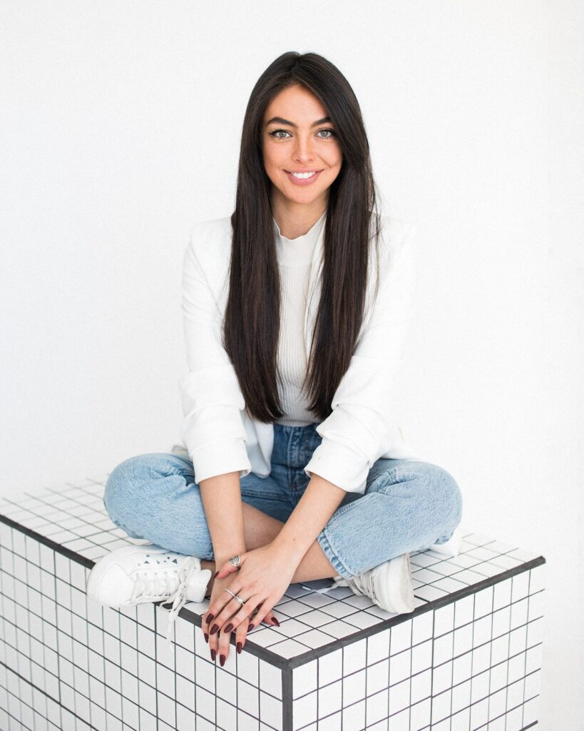 Sharissa Villanueva sitting cross-legged on a white tiled cube