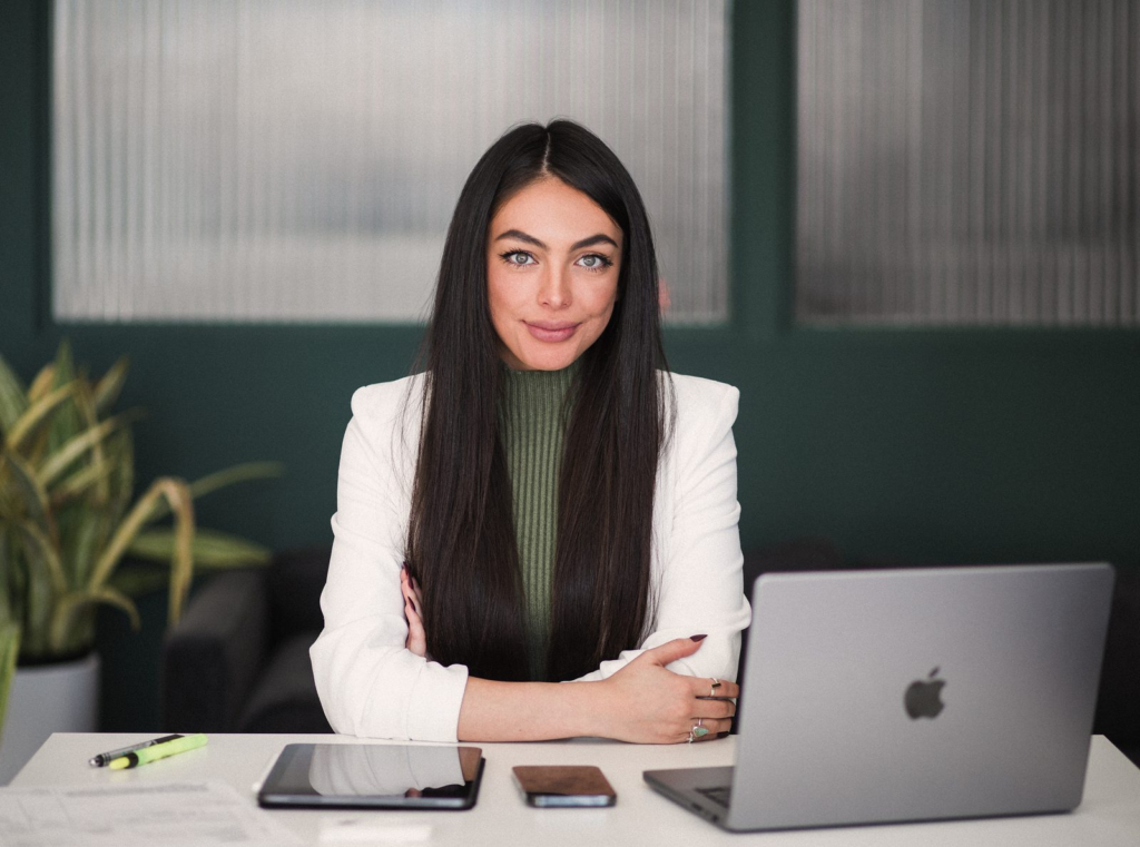 Sharissa Villanueva at her desk with a laptop, arms crossed
