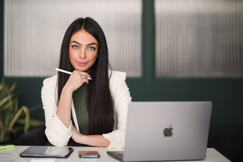 Sharissa Villanueva at her desk with a laptop, pen in hand